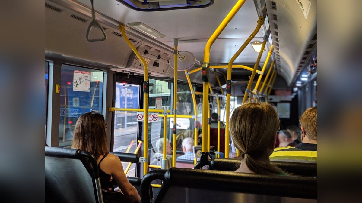 A yellow tram navigating a narrow city street, symbolizing local public transport